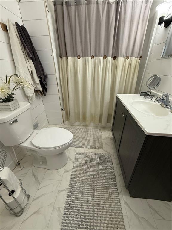 bathroom featuring vanity, curtained shower, toilet, and marble finish floor