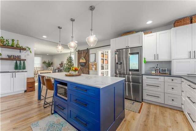 kitchen featuring blue cabinetry, appliances with stainless steel finishes, white cabinetry, and light wood-type flooring