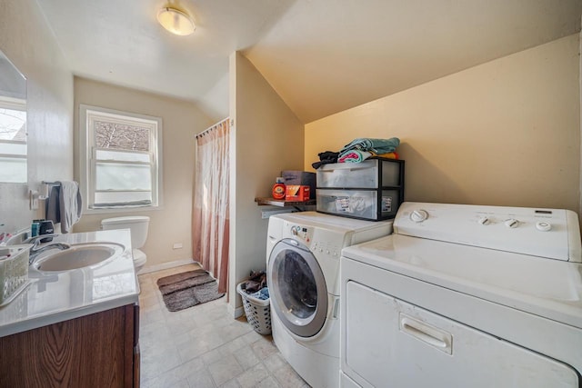 laundry area featuring a sink, baseboards, laundry area, and washer and dryer