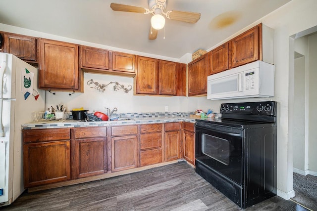 kitchen with brown cabinets, a ceiling fan, a sink, white appliances, and light countertops