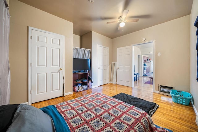 bedroom with ceiling fan, baseboards, a closet, light wood-style floors, and heating unit