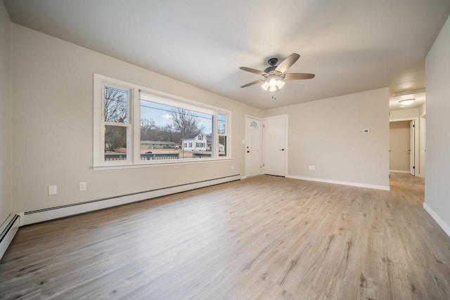 unfurnished room featuring baseboard heating, baseboards, ceiling fan, and wood finished floors