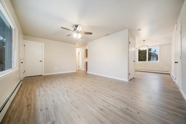 unfurnished room with light wood-style floors, baseboards, baseboard heating, and ceiling fan with notable chandelier