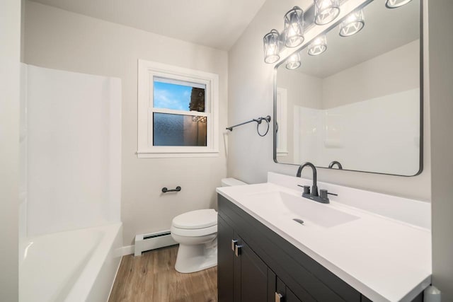 full bathroom featuring vanity, washtub / shower combination, wood finished floors, a baseboard radiator, and toilet