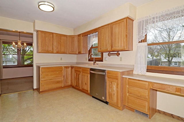 2325 Stuart Ct, Madison, WI 53704 - kitchen with an inviting chandelier, a sink, light countertops, light floors, and stainless steel dishwasher