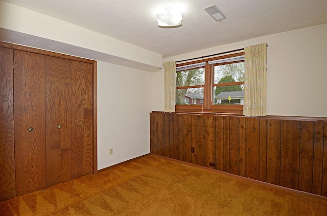 2325 Stuart Ct, Madison, WI 53704 - unfurnished bedroom featuring visible vents, a closet, wainscoting, wood walls, and carpet flooring