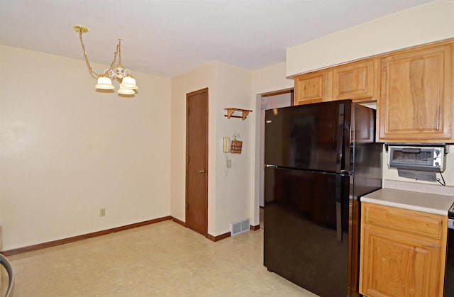 2325 Stuart Ct, Madison, WI 53704 - kitchen featuring visible vents, freestanding refrigerator, light floors, light countertops, and a notable chandelier