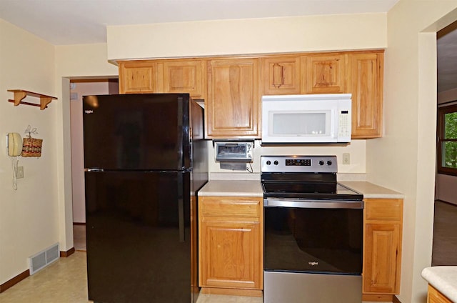 2325 Stuart Ct, Madison, WI 53704 - kitchen featuring stainless steel range with electric cooktop, light countertops, freestanding refrigerator, white microwave, and visible vents
