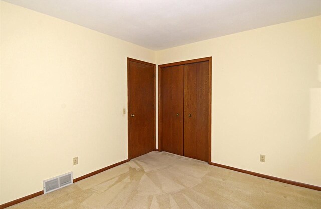 2325 Stuart Ct, Madison, WI 53704 - unfurnished bedroom featuring a closet, baseboards, light colored carpet, and visible vents