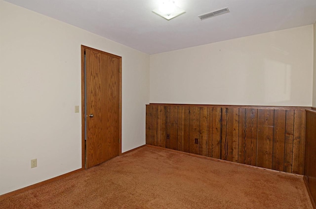 2325 Stuart Ct, Madison, WI 53704 - spare room featuring wooden walls, carpet flooring, and visible vents
