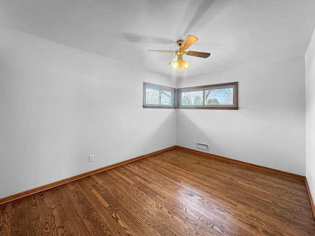 unfurnished room featuring baseboards, a ceiling fan, and wood finished floors