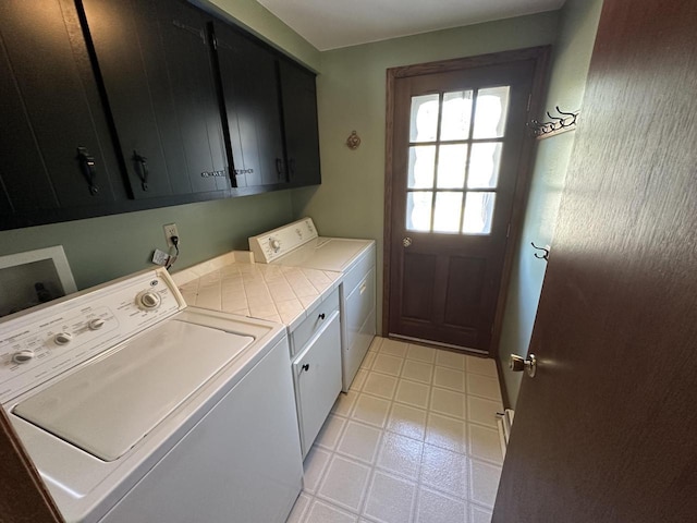 laundry area featuring cabinet space, light floors, and washing machine and dryer