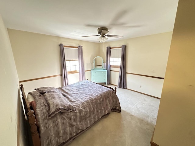 bedroom featuring light colored carpet, baseboards, and ceiling fan