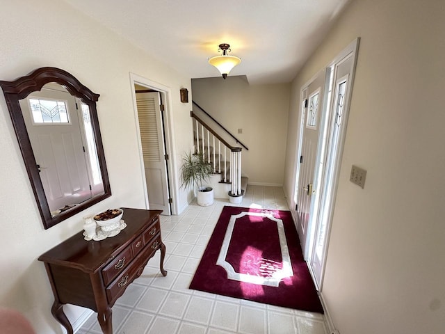 tiled foyer entrance with stairway and baseboards