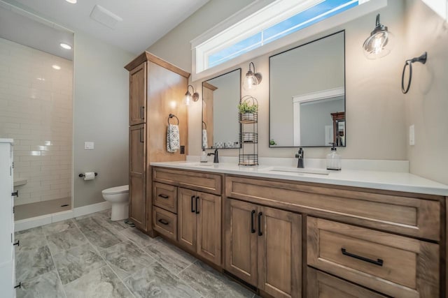 full bathroom featuring double vanity, toilet, walk in shower, and a sink