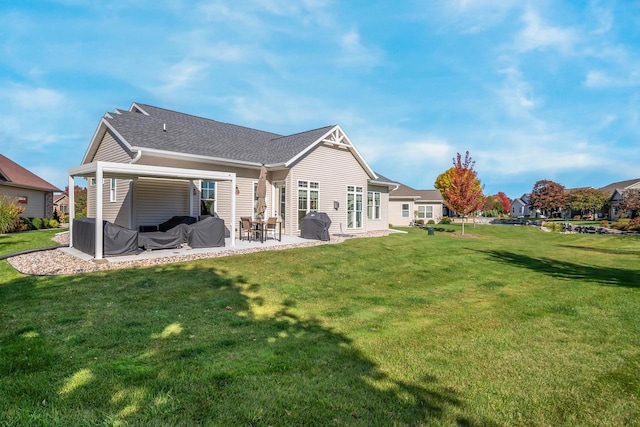 rear view of property with a yard, a patio, and a shingled roof