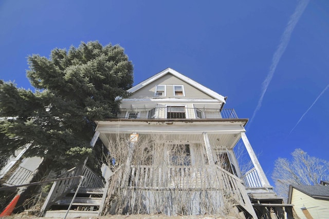 view of front of property featuring a balcony and stairway