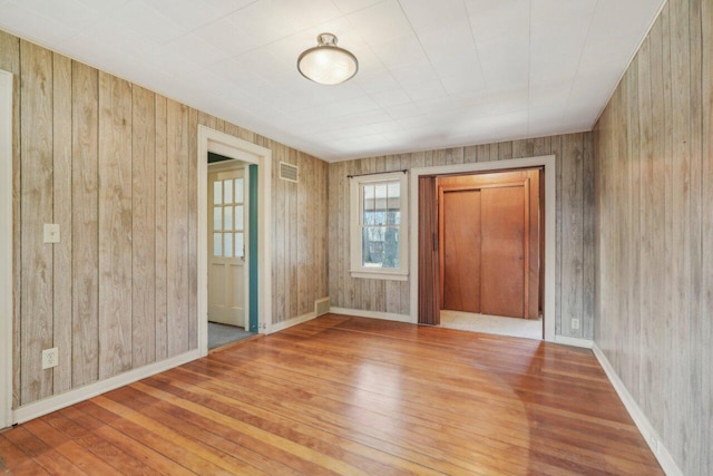 spare room featuring visible vents, baseboards, and hardwood / wood-style flooring