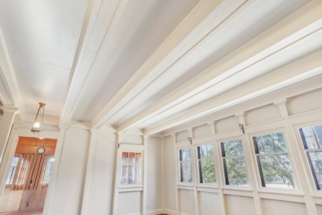 interior space featuring beamed ceiling and decorative columns