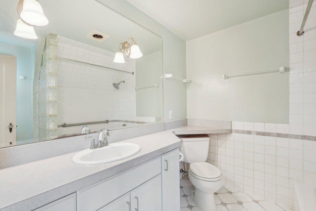 full bathroom with vanity, walk in shower, wainscoting, tile walls, and toilet