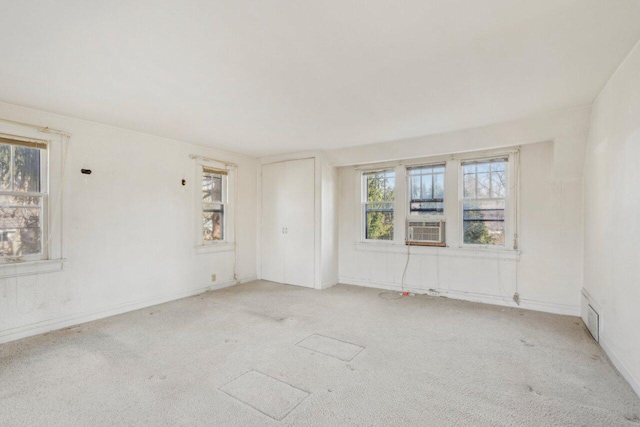 spare room featuring cooling unit and light colored carpet