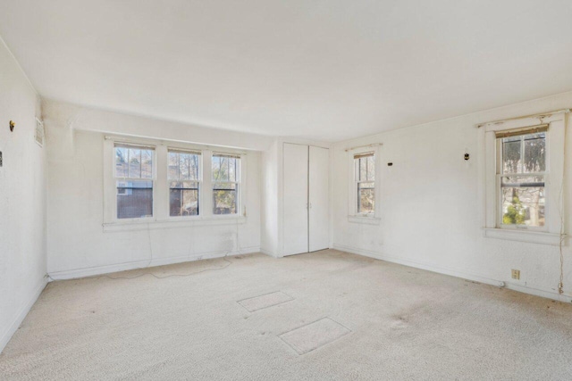 empty room with a wealth of natural light and carpet flooring