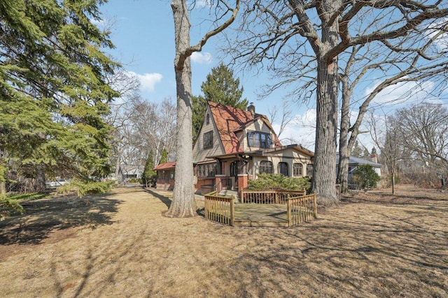 exterior space with brick siding, a chimney, and a deck