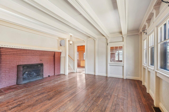 unfurnished living room with visible vents, a brick fireplace, baseboards, beam ceiling, and hardwood / wood-style flooring