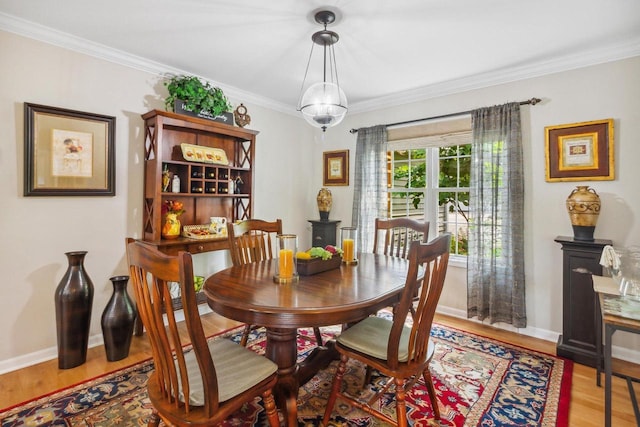 dining area with ornamental molding, baseboards, and wood finished floors