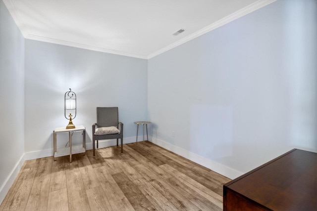 sitting room with visible vents, ornamental molding, baseboards, and wood finished floors