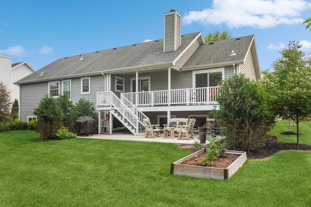 rear view of property featuring a yard, a vegetable garden, a chimney, and a patio area