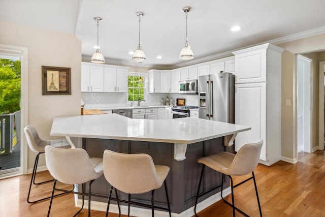 kitchen featuring backsplash, white cabinets, high quality appliances, and light wood-style flooring