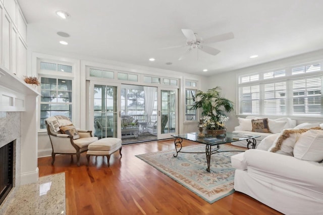 living room with ceiling fan, recessed lighting, wood finished floors, and a premium fireplace