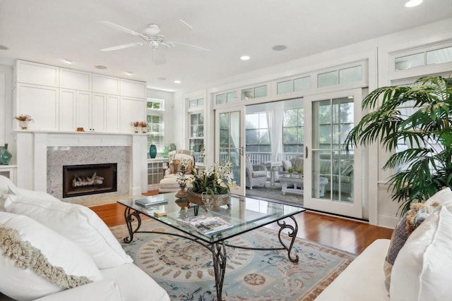 living room with recessed lighting, a premium fireplace, wood finished floors, and ceiling fan