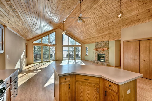 kitchen with light wood-style flooring, a fireplace, open floor plan, and a ceiling fan