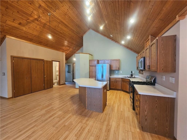 kitchen with a sink, stainless steel appliances, high vaulted ceiling, and light countertops