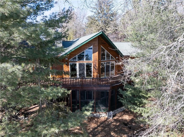 rear view of property featuring a deck and a sunroom