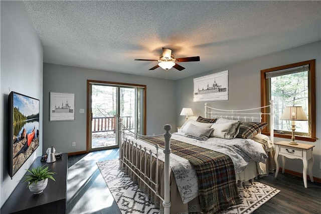 bedroom featuring access to exterior, multiple windows, a ceiling fan, and wood finished floors