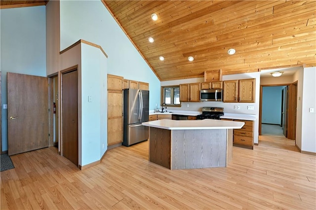 kitchen featuring wood ceiling, light countertops, light wood-style flooring, appliances with stainless steel finishes, and a sink