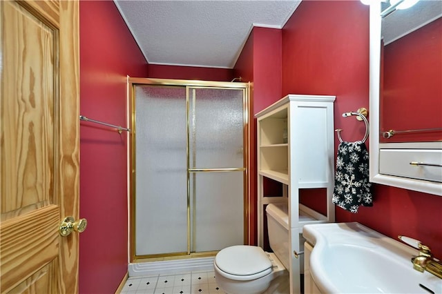 full bathroom featuring a textured ceiling, toilet, a stall shower, and a sink