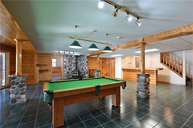 playroom featuring wood walls, a dry bar, a wood stove, and billiards