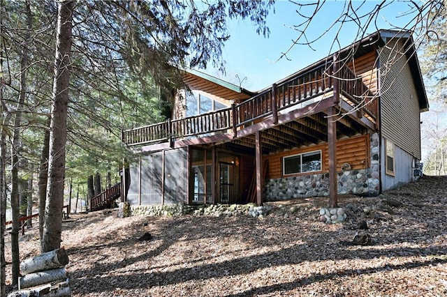 rear view of property with a wooden deck and a sunroom