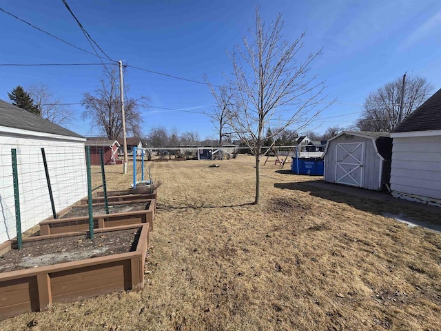 view of yard featuring a storage shed, a garden, and an outdoor structure