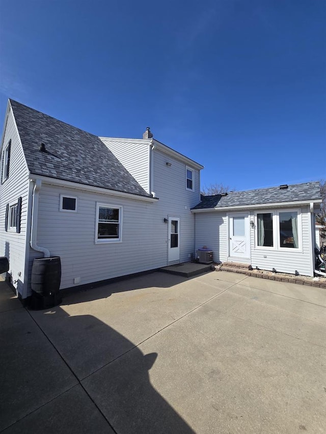 back of property featuring a patio area, central AC, and a chimney