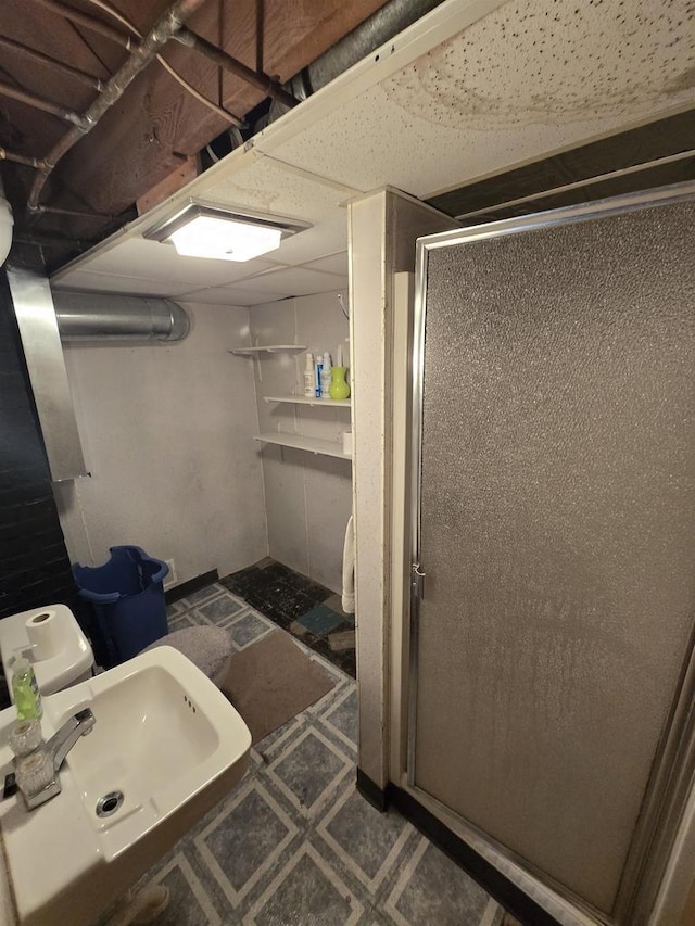 full bath featuring a sink, a shower stall, and tile patterned floors