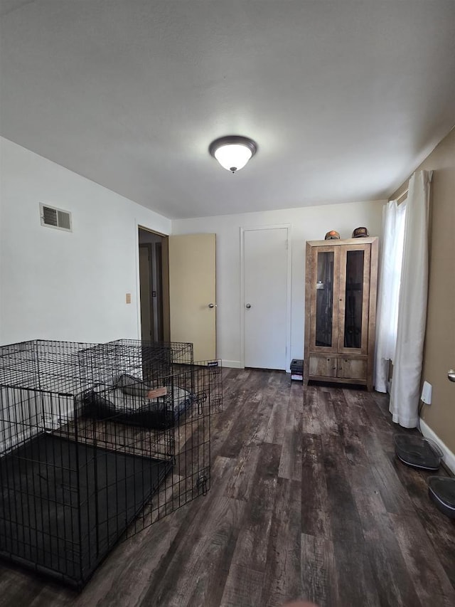 living area featuring visible vents, baseboards, and wood finished floors