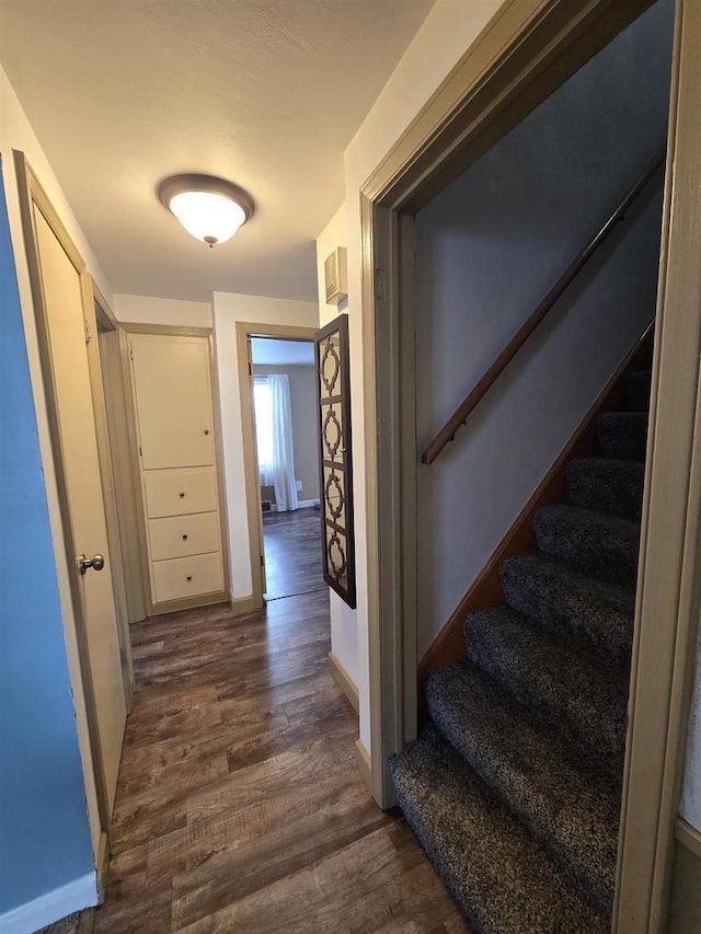 hall with stairs, baseboards, and dark wood-style flooring