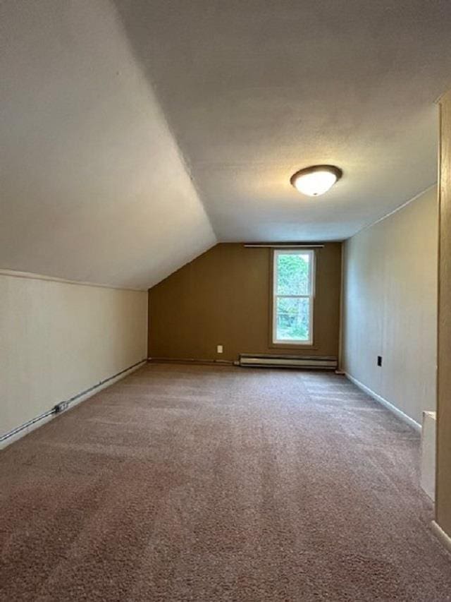 bonus room with a baseboard heating unit, lofted ceiling, and carpet floors