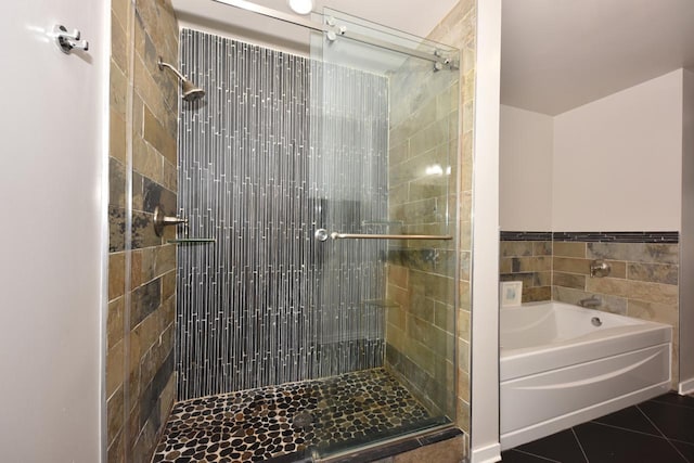 bathroom with tile patterned floors, a stall shower, and a bath