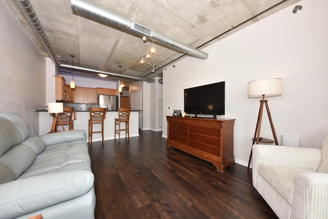 living room with dark wood-style floors, visible vents, and baseboards